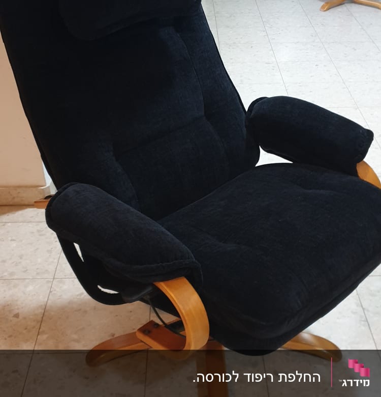 כורסה מרופדת בצבע שחור עם רגלי עץ